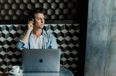 Un homme devant son pc écoutant un podcast