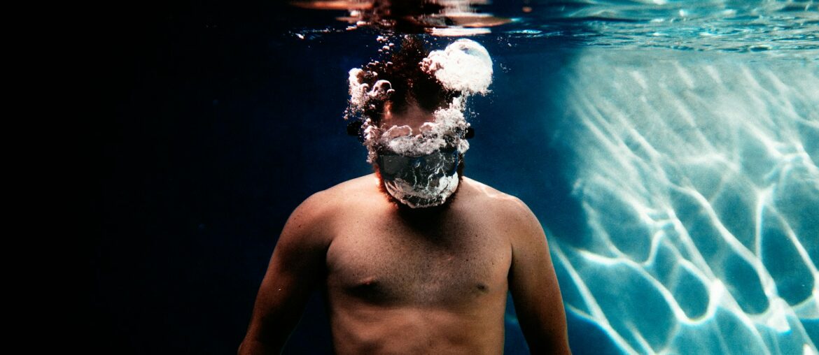 Un homme sous l'eau faisant des bulles