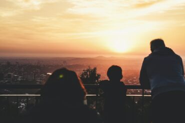 Un père et son fils devant un coucher de soleil